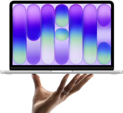 MacBook Neo couleur argent, en équilibre sur le bout des doigts d’une main ouverte, l’écran affichant un motif abstrait coloré