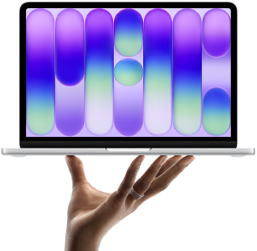 MacBook Neo couleur argent, en équilibre sur le bout des doigts d’une main ouverte, l’écran affichant un motif abstrait coloré