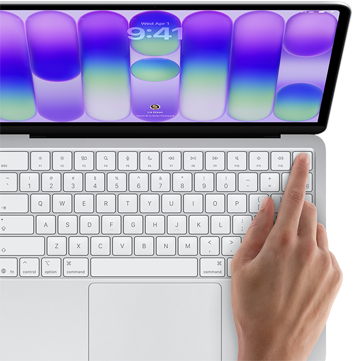 MacBook Neo, couleur argent, affichant l’écran de connexion, doigt d’une personne sur le capteur Touch ID situé dans le coin supérieur droit du clavier